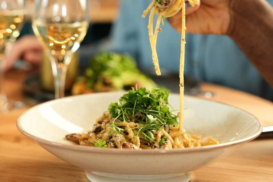 Things to do in East Cambridgeshire - Bens Yard. Close up of a plate of spaghetti carbonara and a glass of white wine