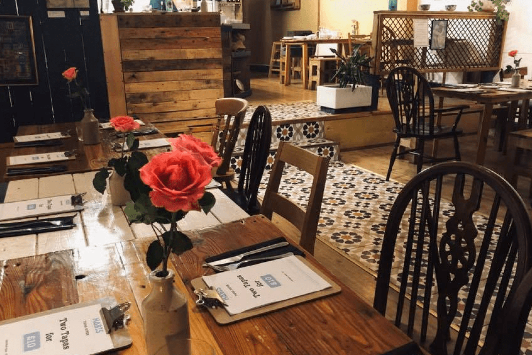 Places to eat in East Cambridgeshire - Habi's Restaurant. Image of restaurant interior. Roses on table and tiled floor.