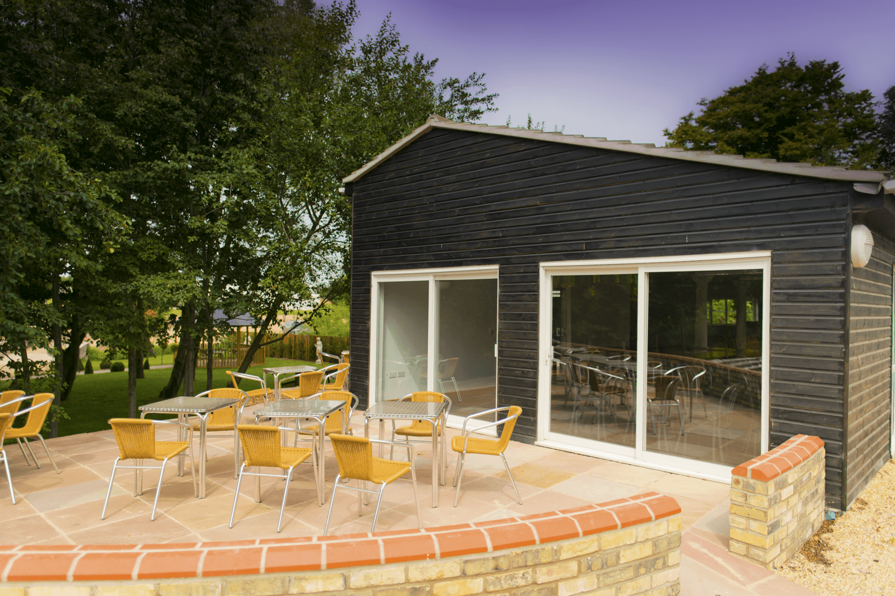 Places to stay in East Cambridgeshire - Rosewood Stud. Photo of exterior of wooden building with outdoor patio.