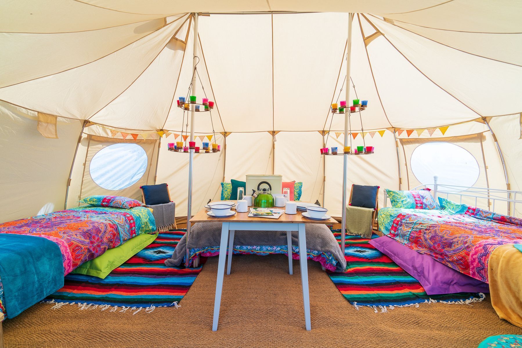 Places to camp in East Cambridgeshire - Hatters Meadows. Image of tent interior with colourful rugs and bunting