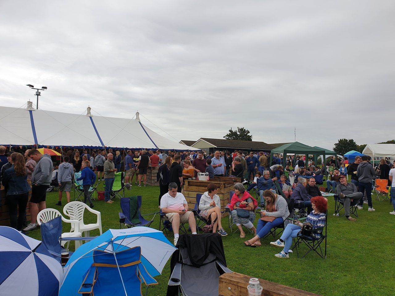 Things to do in East Cambs in Summer- Haddenham Beer Festival. Groups of people on picnic chairs on grass